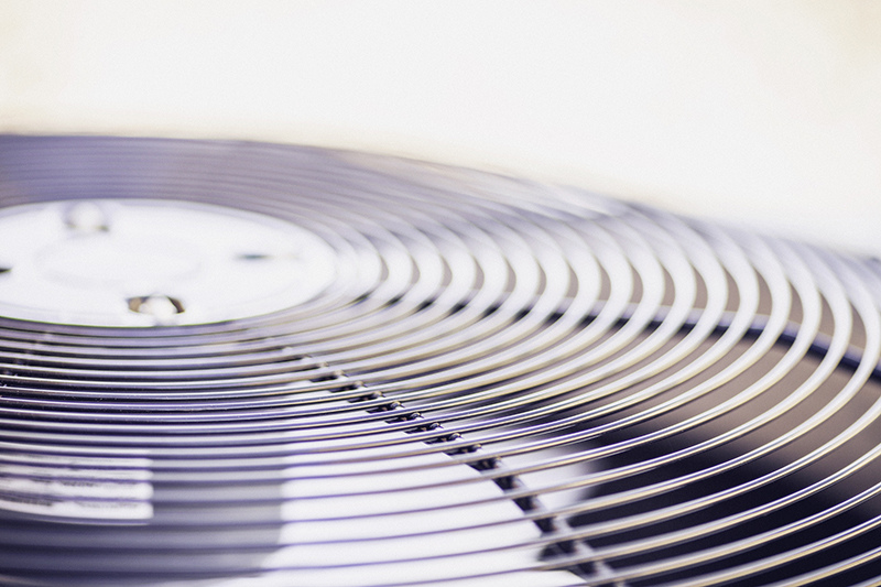 HVAC Refrigerant and SEER Changes in 2025. Close up photo of an AC Unit fan.