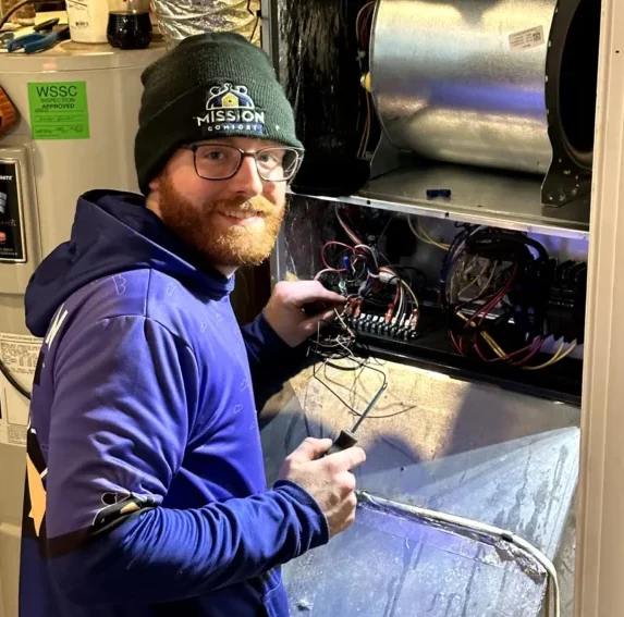 Mission Comfort tech repairing air conditioner